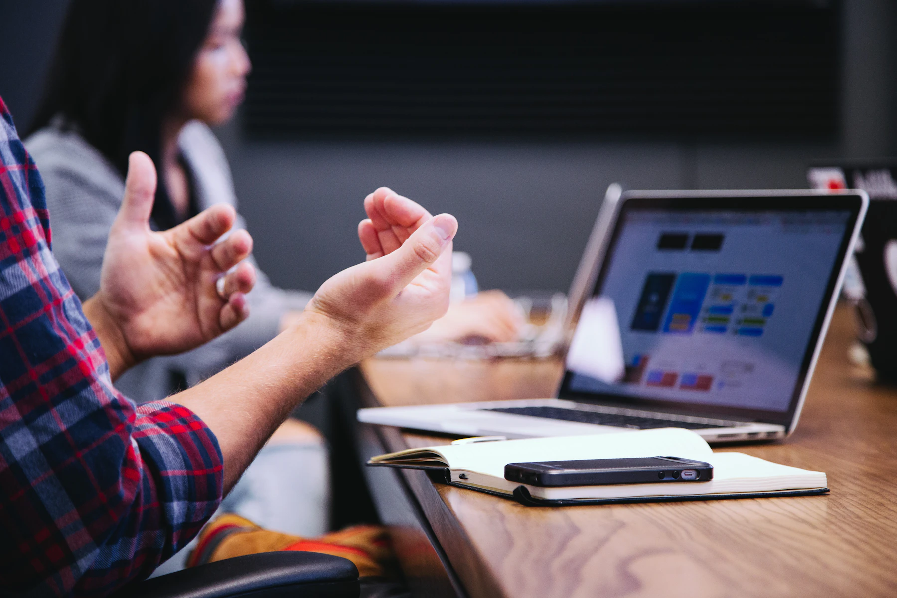 Gesto representativo durante uma conversa profissional em mesa de trabalho